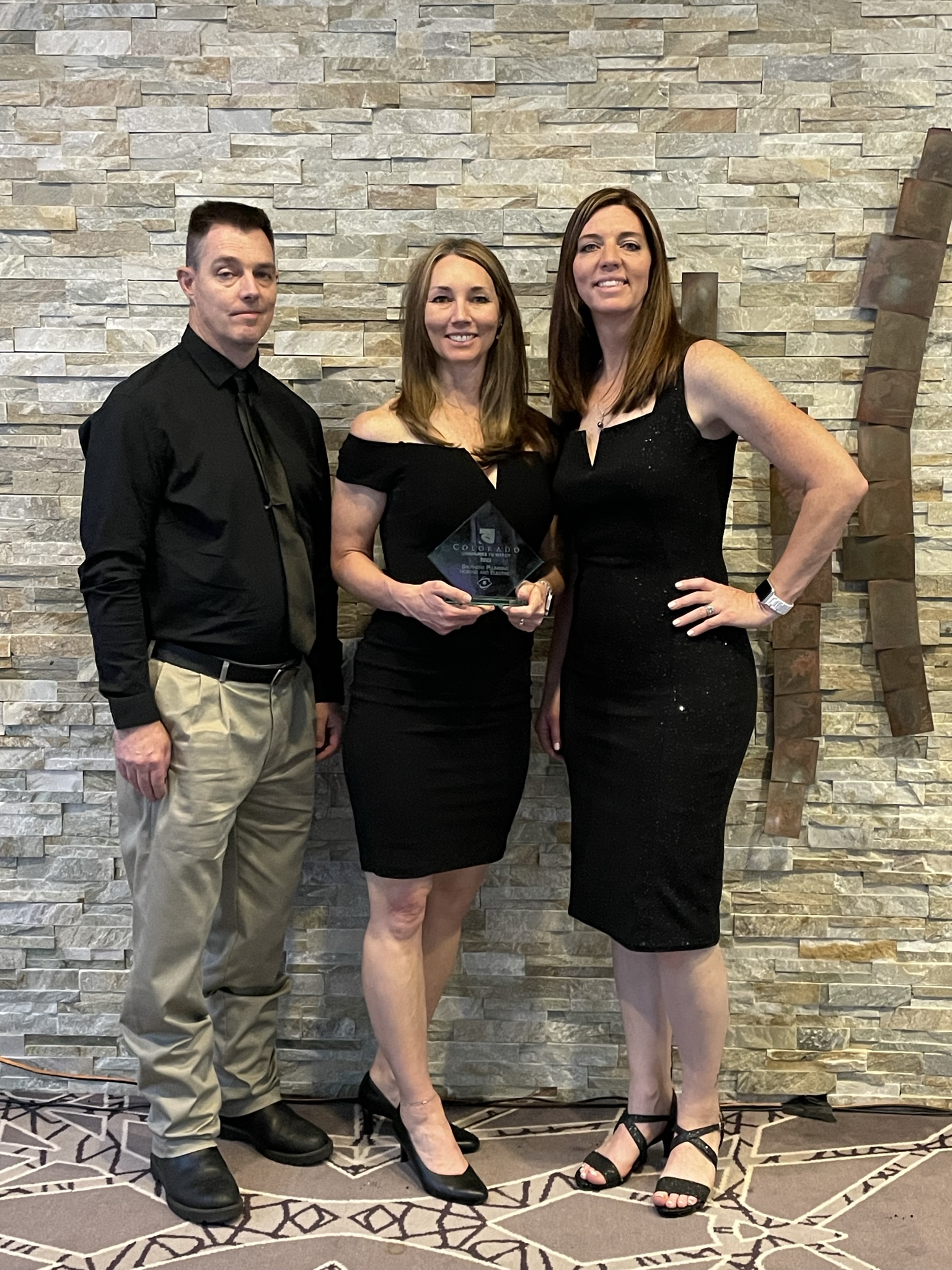 Lynn, Justin and Michelle standing together at an award ceremony.