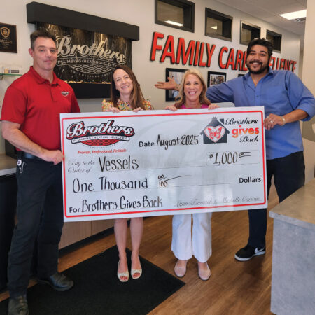 Justin and Tony Standing in for the Sisters of Brothers presenting a $1000 check to Vessels