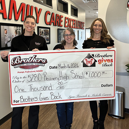 Lynn & Michelle, the Sisters From Brothers, present a check for $1,000 to 5280 High School