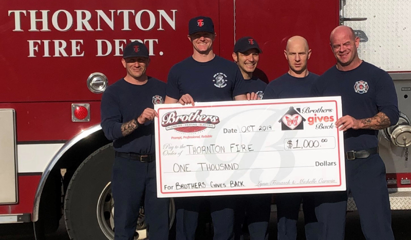 Brothers gives back to the Thornton fire department featured image of the fire depot holding a giant novelty check